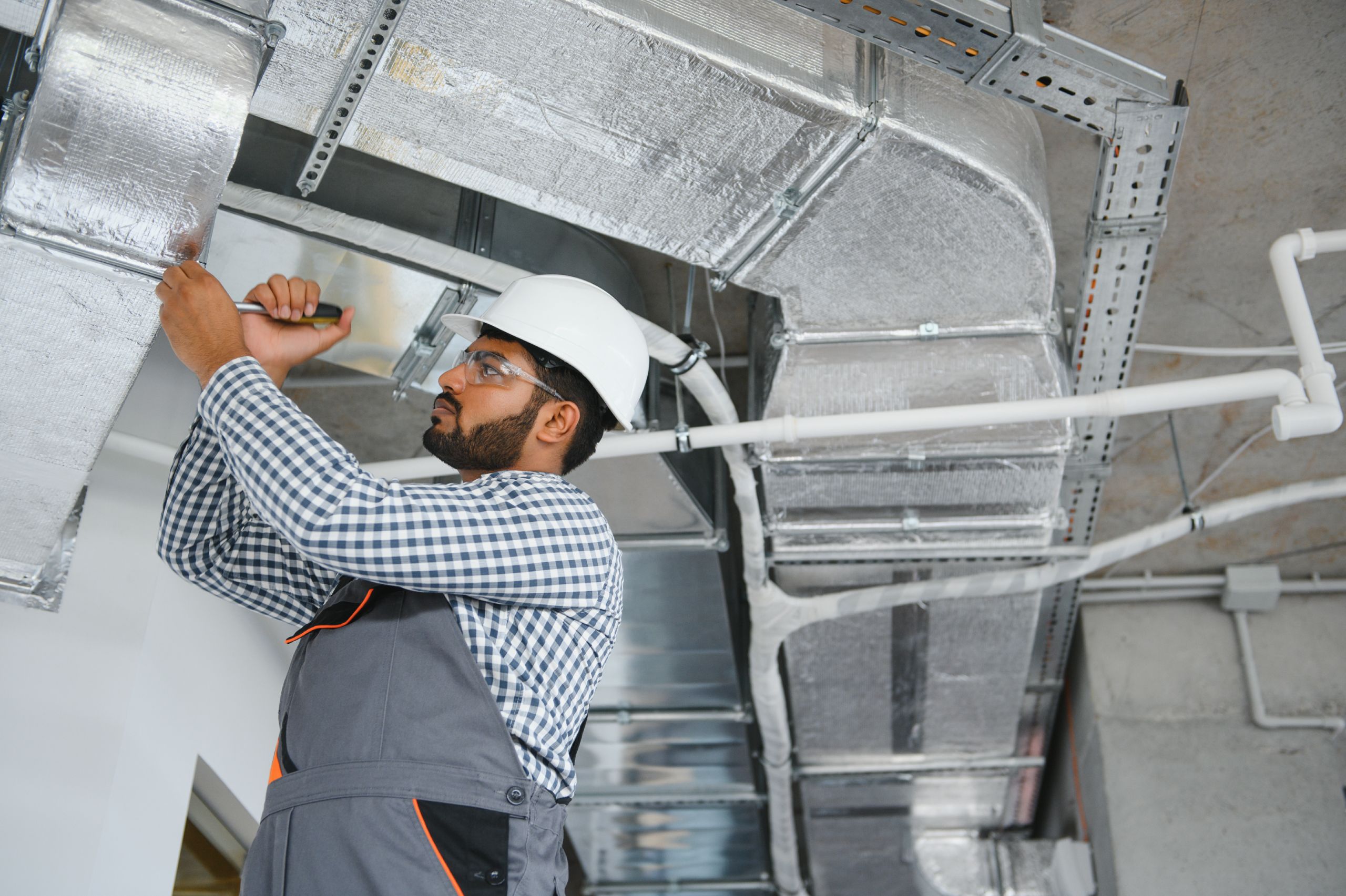 indian-worker-inspects-ventilation-system-office-building